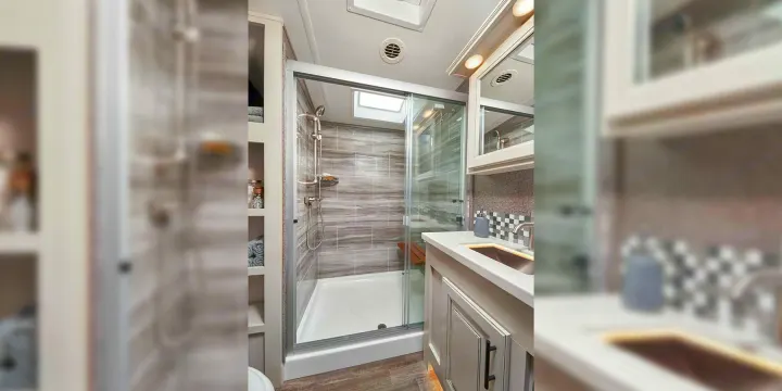 Compact yet complete RV rental bathroom: walk-in shower with sky light, vanity, and practical shelving.. Jayco Pinnacle 2022