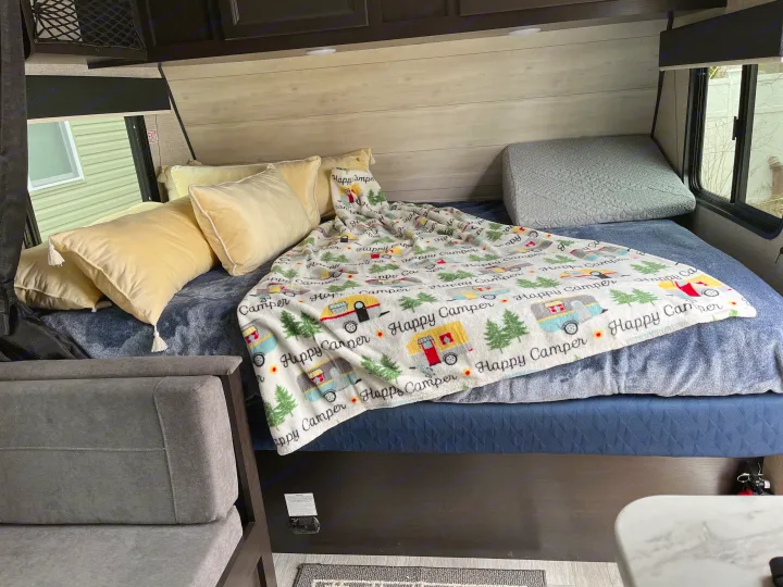 RV rental bedroom featuring a comfy bed, "Happy Camper" blanket, and plush pillows.. Jayco Jay Flight SLX STX Edition 2022