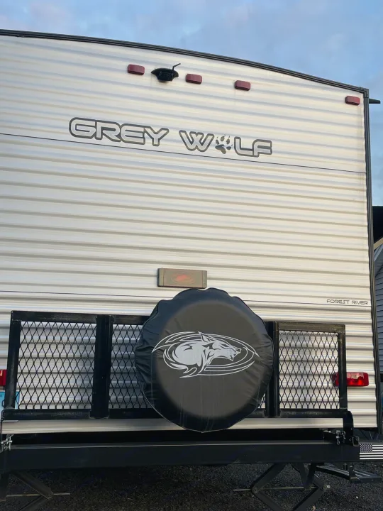 Get ready for adventure! This Grey Wolf rv rental shows its rear with spare tire, cargo rack, and backup camera.. Forest River Cherokee Grey Wolf 2022