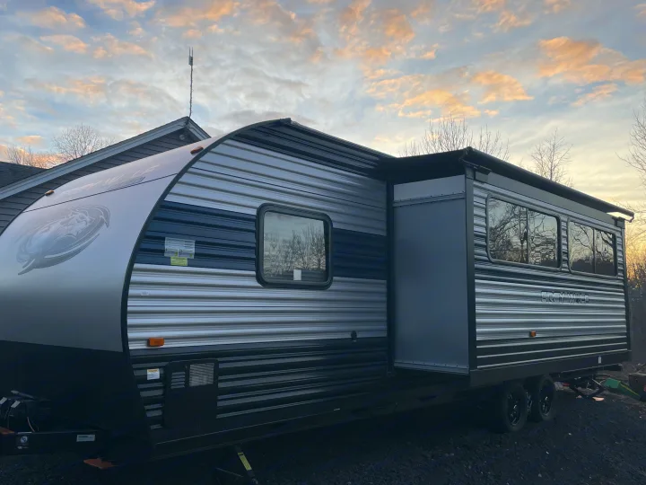 Spacious Grey Wolf RV rental with slide-out extended, parked outdoors under a cloudy sky.. Forest River Cherokee Grey Wolf 2022