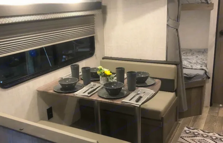 RV rental with modern interior: dinette set for four, window, and bunk beds. Perfect for family adventures.. Gulf Stream Ameri-Lite 2022