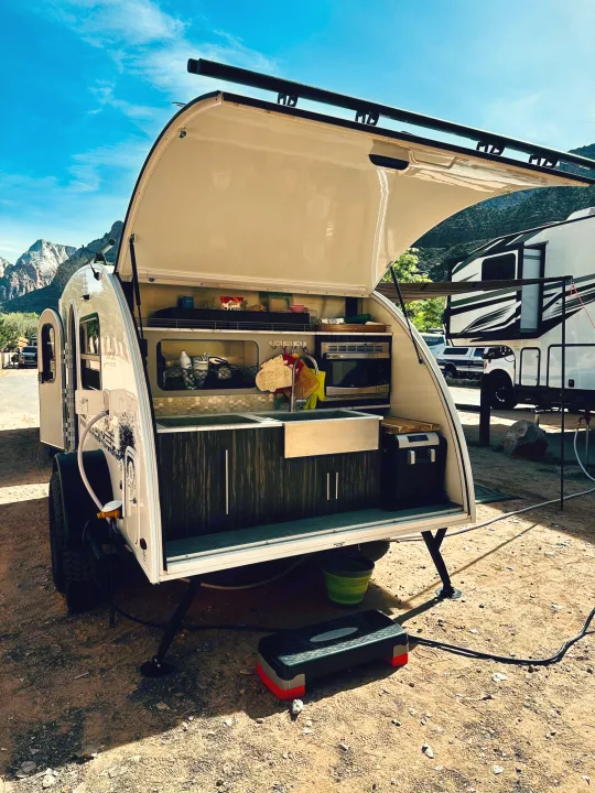 This teardrop RV rental showcases its functional outdoor kitchen, ready for camping trips & scenic views.. InTech RV InTech RV Trailer 2021