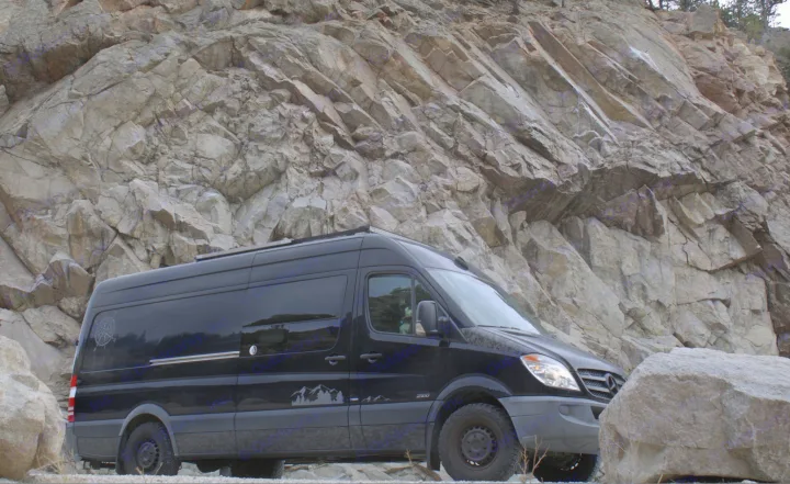 Black Mercedes Sprinter RV rental for rugged mountain adventures, parked by a rock cliff.. Mercedes Sprinter 2012