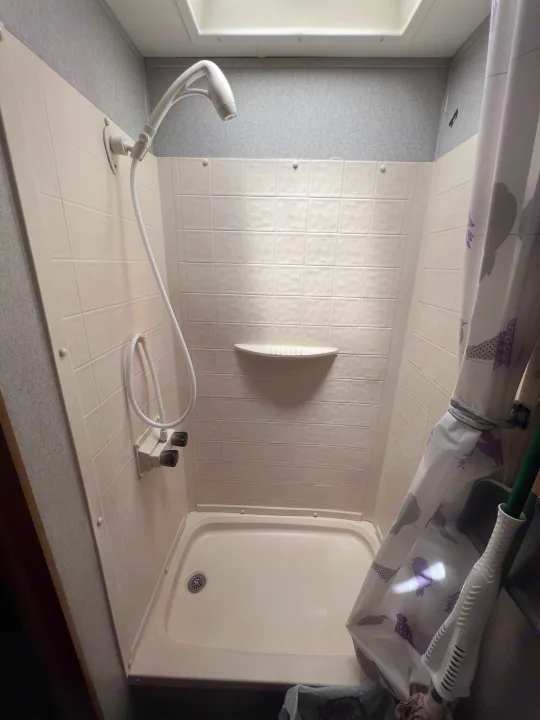 Step inside this clean, compact shower in an RV rental, complete with a handheld shower head and a patterned curtain.. Coachmen Other 2019