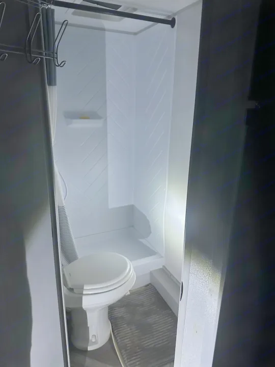 RV rental bathroom with a compact toilet and shower stall featuring herringbone walls and a grey mat.. Forest River Salem FSX PLATINUM 2021