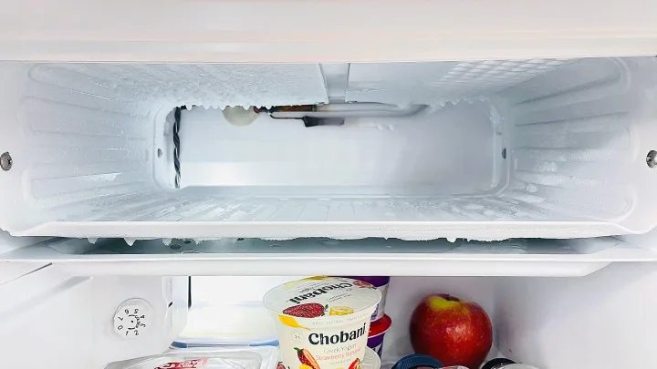 Heavy frost in an RV rental freezer, ice encasing cooling coils. Defrosting is urgent for optimal refrigeration.. Winnebago SOLIS 59 PX 2023