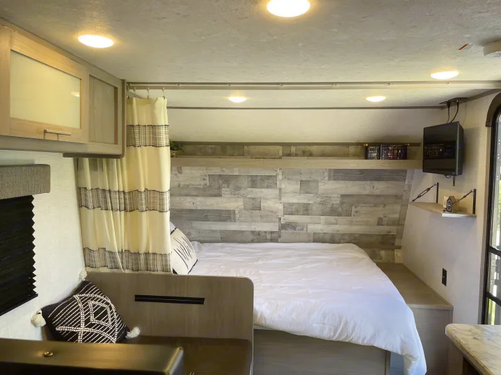 Cozy RV rental bedroom & living space, featuring a bed, seating, and storage, perfect for your next travel.. Dutchmen Coleman Lantern LT 2023