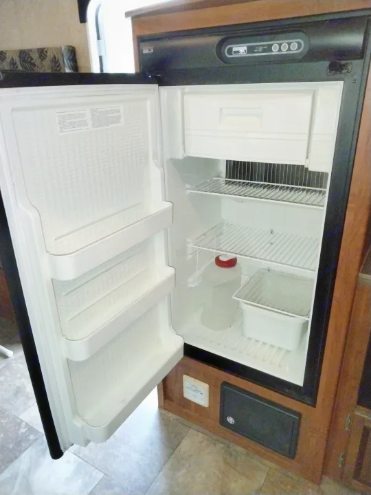 An open Norcold refrigerator inside an RV rental. Features adjustable shelves, a freezer compartment, and door storage.. Jayco Jay Feather Ultra Lite 2013