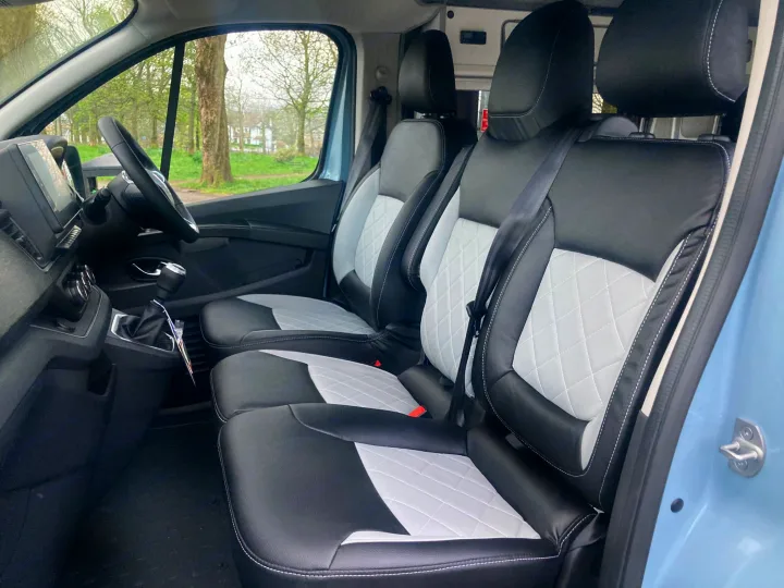 Step into this RV rental van's modern interior: 3 seats with black & white quilted upholstery, plus a clear dash.. Renault Trafic - PAISLEY 2023