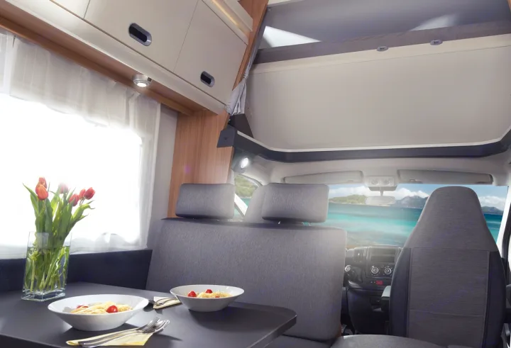Experience your RV rental: a cozy dining area with fresh pasta, tulips, and a stunning ocean view right from your seat.. SunLiving A 75 DP 23 2023