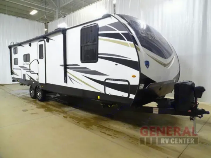 Explore with this white Outback travel trailer, featuring black/gold graphics, ideal for your rv rental adventure. Pictured indoors.. Keystone RV Outback Ultra-Lite 2021