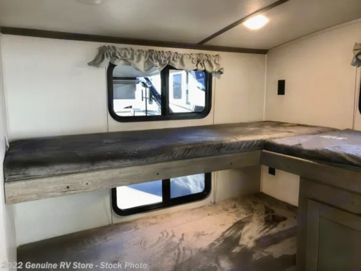 RV rental interior featuring L-shaped bunk beds, bright lighting, and multiple windows.. Keystone RV Outback Ultra-Lite 2021