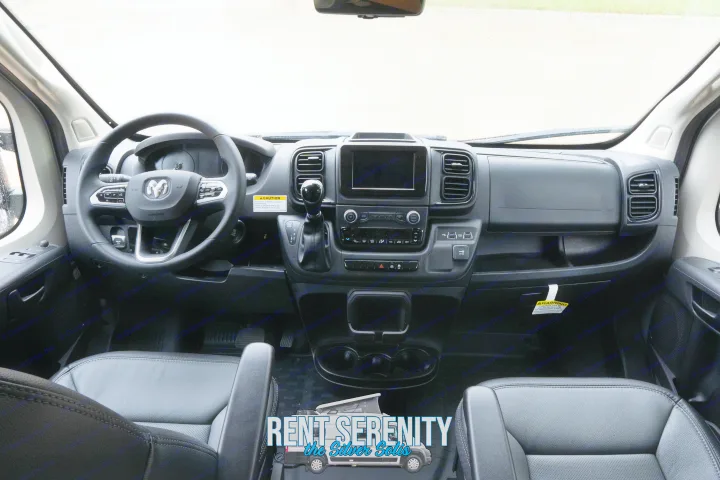 Modern RV rental interior showing the sleek dashboard, steering wheel, and comfortable front seats of a camper van.. Winnebago Solis 2023
