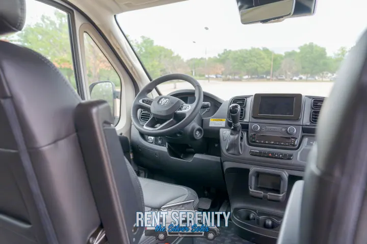 Interior of a modern RV rental van cockpit. Shows steering wheel, dashboard, and gear shift.. Winnebago Solis 2023