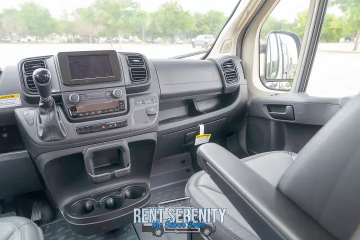 Spacious RV rental interior with a view of the modern dashboard, controls, and comfy passenger seat.. Winnebago Solis 2023