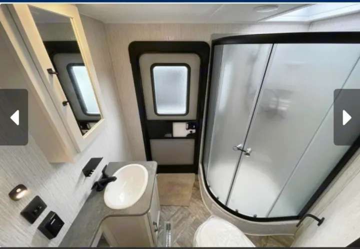 RV rental bathroom: compact design with shower, vanity, toilet, and an exit door visible from inside.. Forest River Palomino Puma 2023
