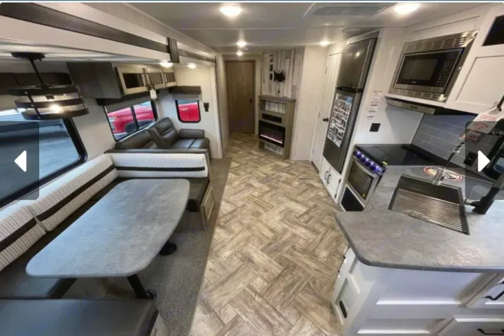 Spacious RV rental interior with dinette, sofa, full kitchen, and fireplace. Ready for your next adventure!. Forest River Palomino Puma 2023