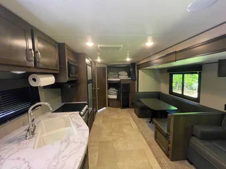 Explore this RV rental's bright interior! Equipped kitchen, comfortable dinette, and bunk beds.. Jayco Jay Flight SLX 2021