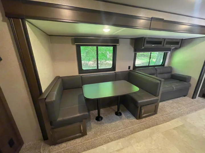 Spacious and comfortable RV rental interior featuring a U-shaped dinette, sofa, and scenic windows.. Jayco Jay Flight SLX 2021