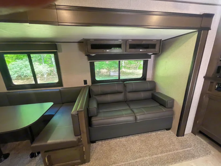 Cozy RV rental interior with a spacious dinette and comfortable sofa, offering a comfortable living space for travel.. Jayco Jay Flight SLX 2021