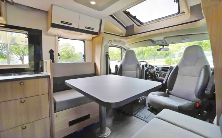 Cozy RV rental interior with dining area, kitchen, and swivel front seats, perfect for comfortable travel adventures.. SunLiving S 72 DL 2023