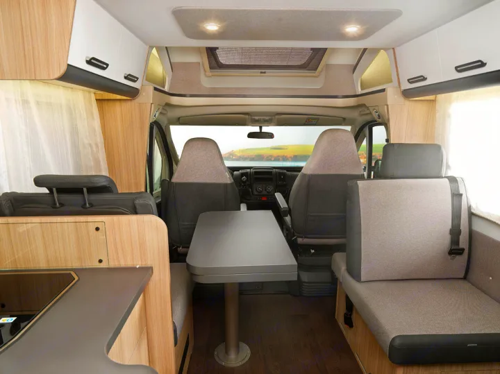 Explore an RV rental's spacious campervan interior, featuring a dinette, kitchenette, swivel seats, and ample storage for your road trip.. SunLiving S 72 DL 2023