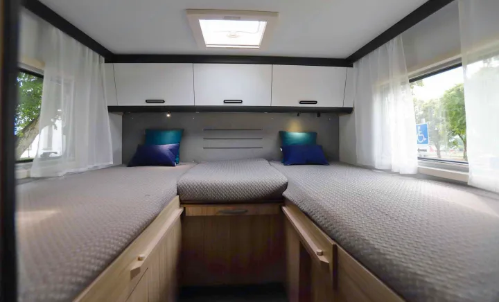 RV rental: Bright bedroom with two single beds, a middle extension, white overhead cabinets, & sheer window curtains.. SunLiving S 72 DL 2023