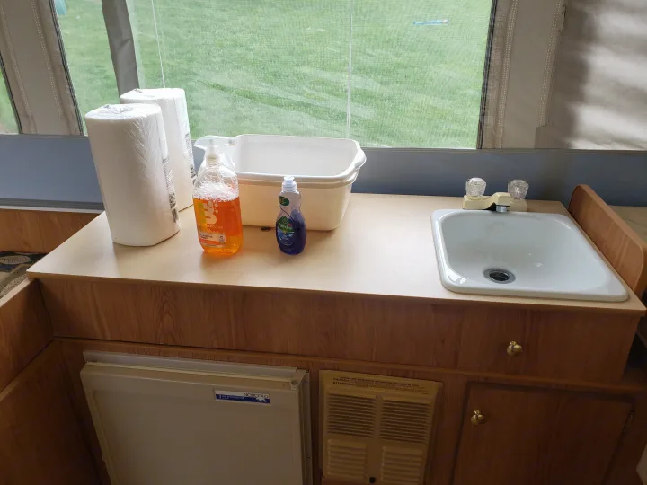 Inside this RV rental, the compact kitchen features a sink, small fridge, paper towels, and cleaning supplies for trips.. Jayco Select 2006