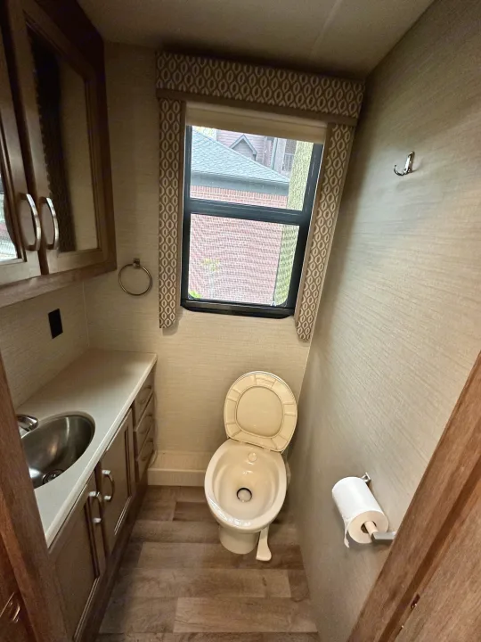 RV rental interior showcasing a compact bathroom and kitchen. Features a toilet, sink, and window.. Jayco Precept 2019