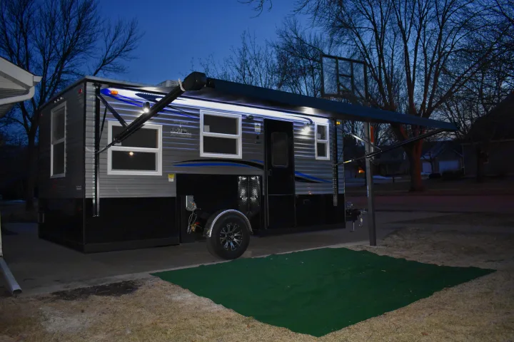 RV rental: a modern, lighted Ice Castle trailer with an extended awning, parked outside at twilight.. Ice Castle Fish Houses Rv Edition Standard 2024