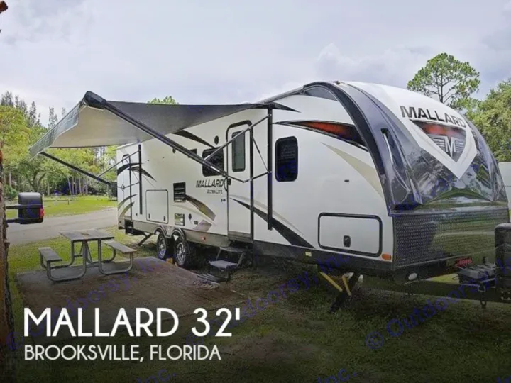 Mallard 32' RV rental in Brooksville, Florida. White travel trailer with extended awning & picnic table.. Heartland RVs Mallard 2019