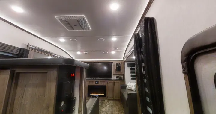 Spacious RV rental living area featuring modern TV, fireplace, and bright lighting for comfort.. Forest River Sabre 2022
