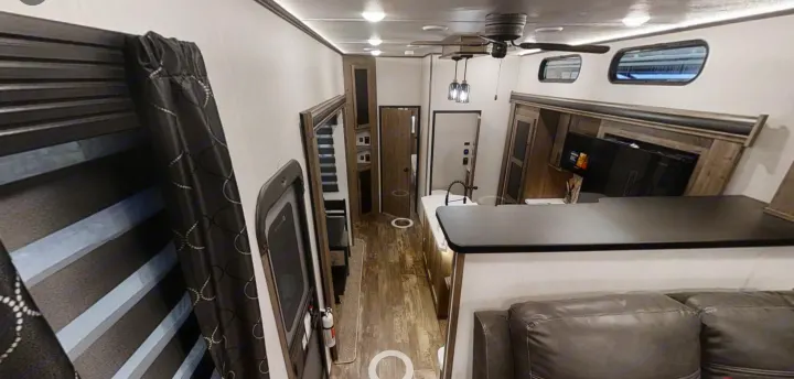 Explore this modern RV rental interior! Features a spacious living area, kitchen counter, entertainment system, and comfortable seating.. Forest River Sabre 2022