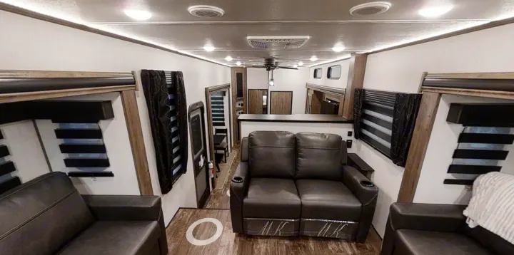 View of a spacious and modern RV rental living area, featuring dark leather recliners and wood grain floors.. Forest River Sabre 2022