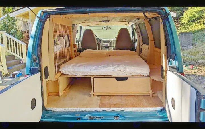 Experience comfort in this camper van rv rental! Features a built-in bed, under-bed storage, and warm wood interior.. Chevrolet Other 1996