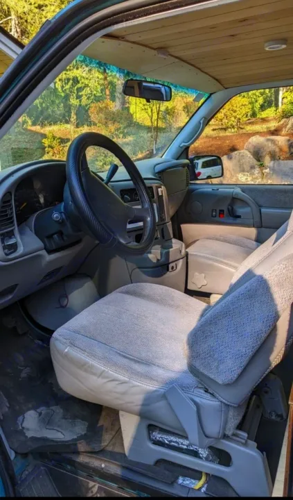 RV rental: Driver's view inside a custom-converted van, showing the steering wheel, dash, seats, and wooden ceiling.. Chevrolet Other 1996