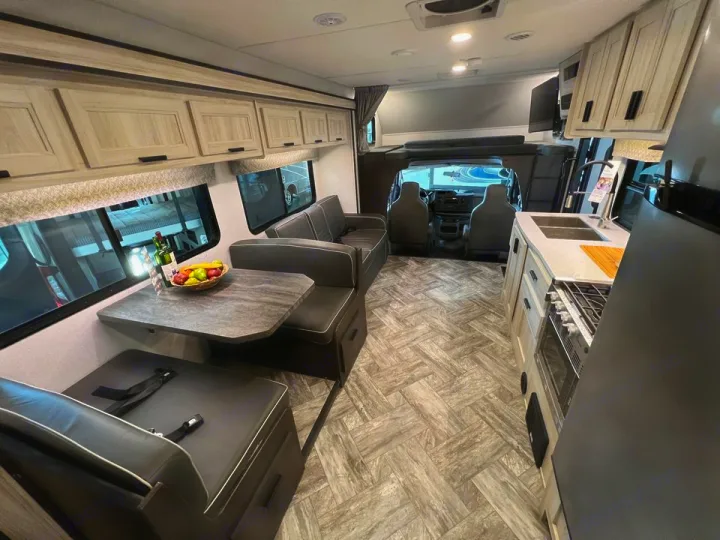 Spacious RV rental interior featuring a modern kitchen, cozy dinette, and front cabin access. Ideal for travel.. Forester LE 2022
