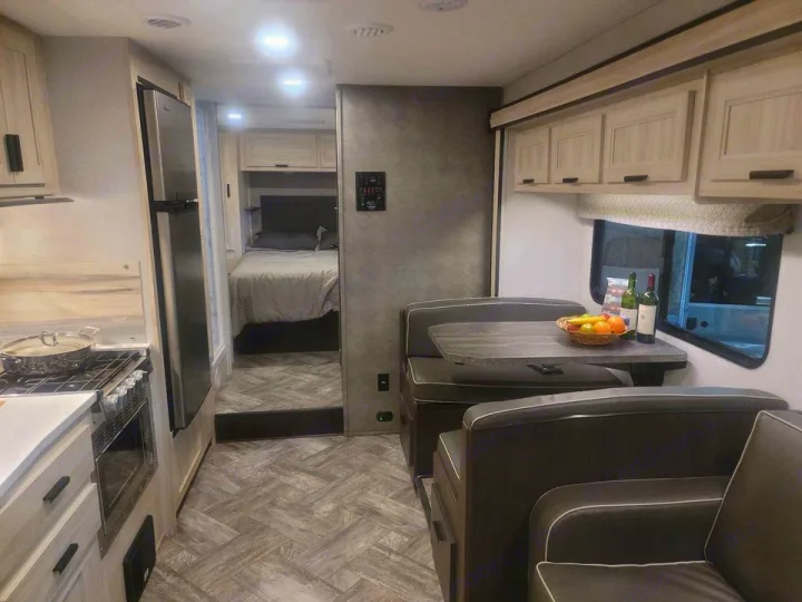 RV rental interior: a bright space with a practical kitchen, dining booth, and a cozy bedroom. Perfect for travel!. Forester LE 2022