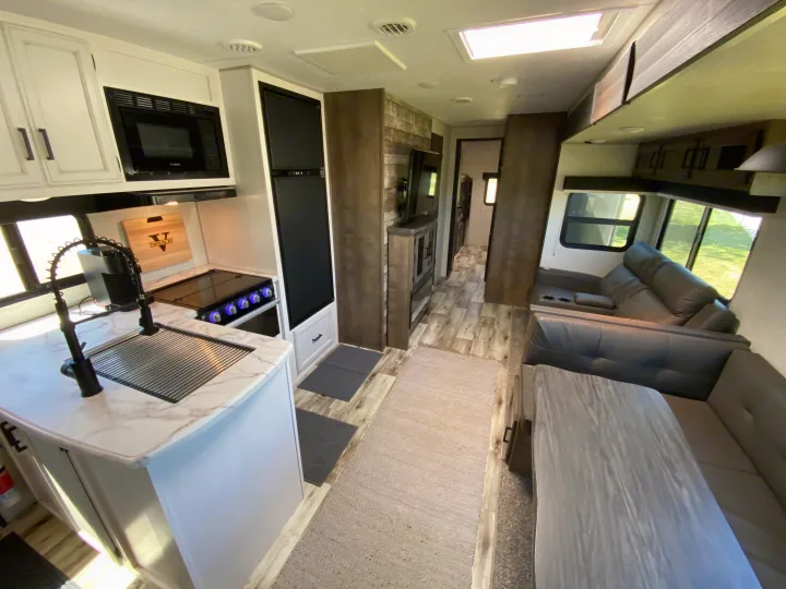 Spacious, modern RV rental interior featuring a well-equipped kitchen, comfortable living area, and clean design.. Venture Sporttrek 2022