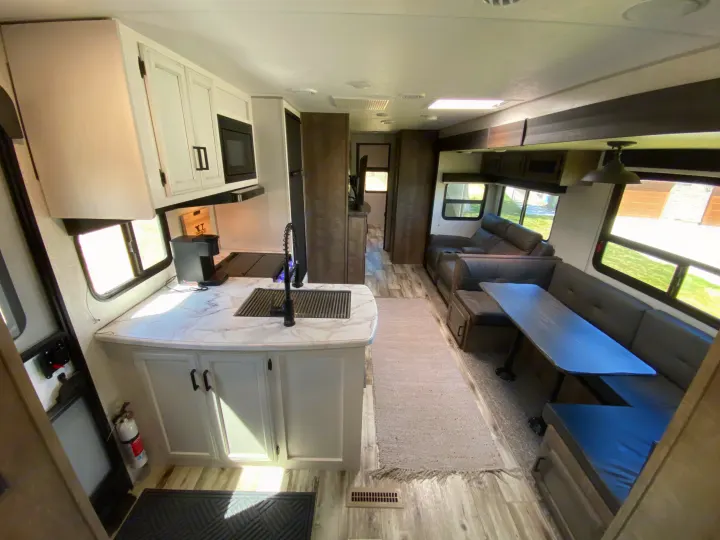 Spacious RV rental interior with modern kitchen, comfy living area, and dinette.. Venture Sporttrek 2022