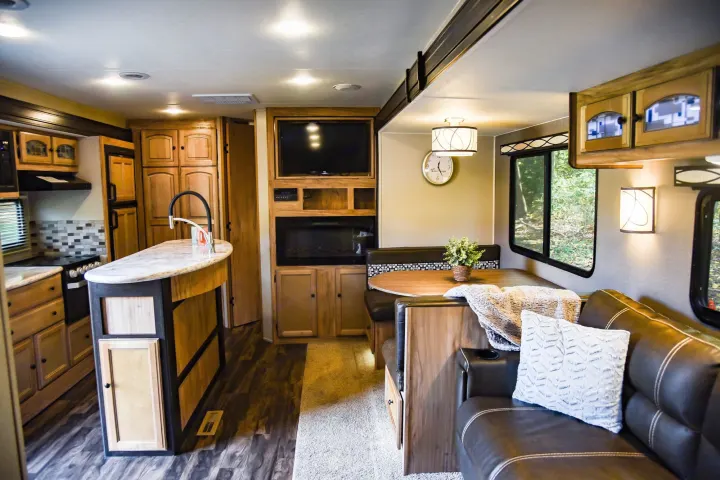 Spacious RV rental interior with kitchen island, dinette, and entertainment center, offering comfort for your travels.. Coachmen Freedom Express 2018