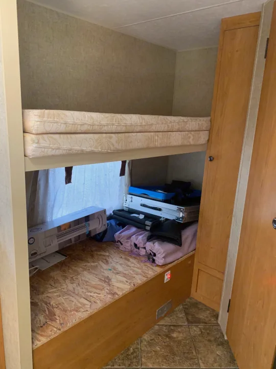RV rental interior featuring bunk beds with stacked mattresses, the lower bunk converted into storage for travel items.. Escape Trailer Industries Escape 5.0ta 2013