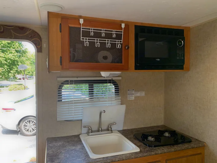This RV rental offers a functional kitchen with a sink, two-burner stove, microwave, and handy overhead storage.. Escape Trailer Industries Escape 5.0ta 2013