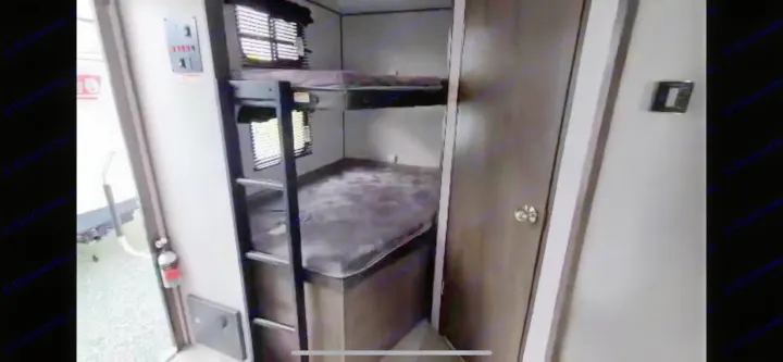 RV rental interior: two bunk beds with ladder, windows, and a side door. Compact, comfortable sleeping space for travel.. Dutchmen Coleman Light 2021
