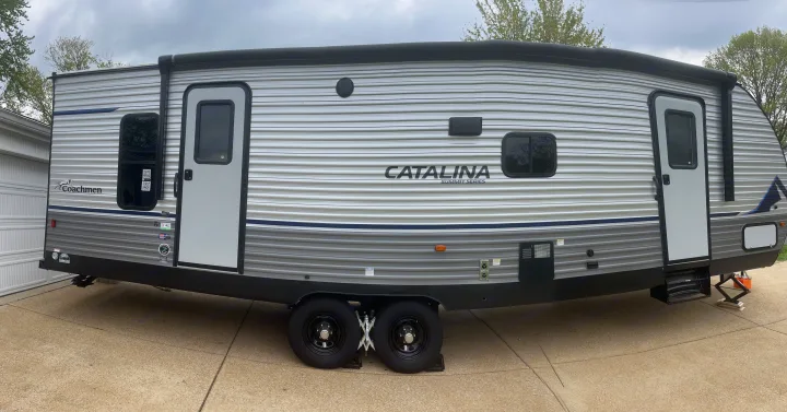 This large, dual-axle Coachmen Catalina travel trailer, ready for an RV rental. Parked on a concrete driveway.. Coachmen Summit series 2023