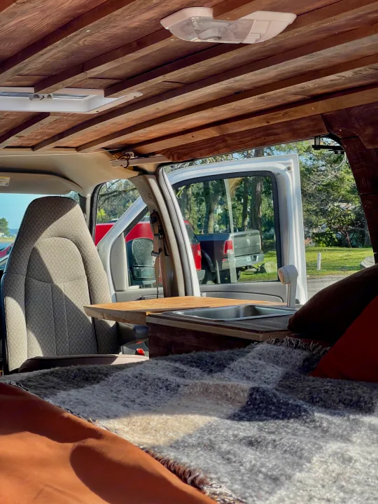 Cozy RV rental interior with wooden ceiling, sink, and comfy bed. Ready for your next travel adventure!. Chevrolet Other 2009