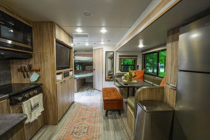Inviting RV rental interior: equipped kitchen, dining area, TV, and bunk beds. Ideal for comfortable travel and family trips.. Winnebago Minnie 2022