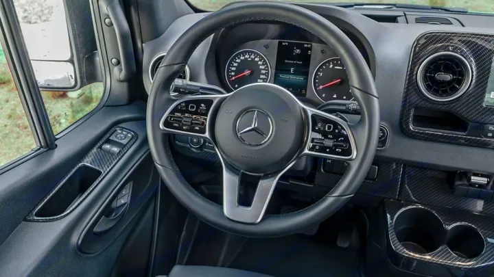 Modern Mercedes-Benz Sprinter RV rental interior: premium design with carbon fiber accents, multifunction steering wheel, & digital dash.. Winnebago Revel 2022