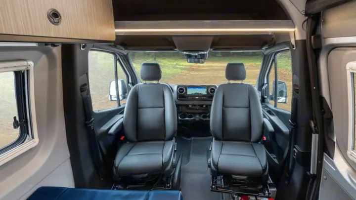 RV rental: Front cabin with black leather seats, dashboard, and overhead storage for your next adventure.. Winnebago Revel 2022