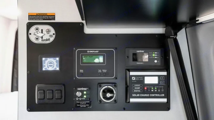 RV rental interior control panel: monitor for solar, power, and water, plus Eurolift bed switch.. Winnebago Revel 2022